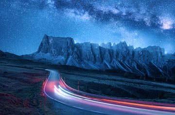 Headlights of car illuminating road in twilight in desert