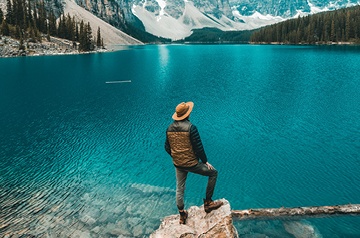 standing lakeside, mountains behind