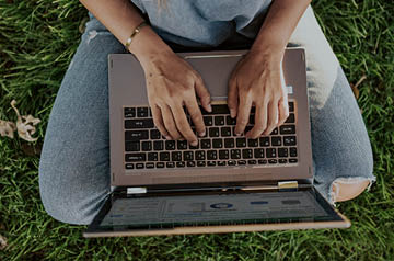 sitting in grass, laptop in lap