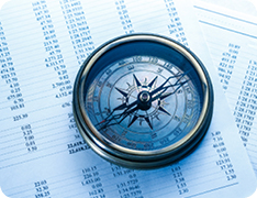 compass on stack of spreadsheets