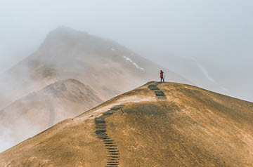 Person standing at the top of a hill