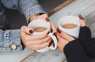 hands holding mugs of coffee