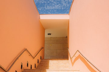 Looking up sunny stairwell to blue sky