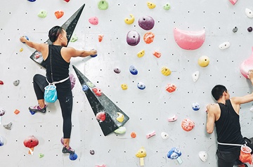 Two rock climbers on an indoor climbing wall