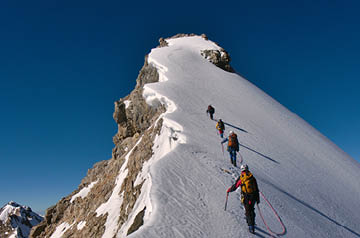 Climbers going up snowy mountain