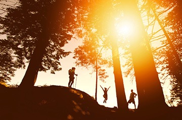 hiker climbing piney hill at sunset