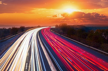 Blurred car lights on a highway while sunrises