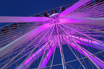 View of a lit Ferris wheel at night.