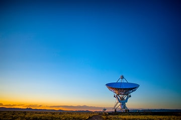 large satellite in open field at dusk